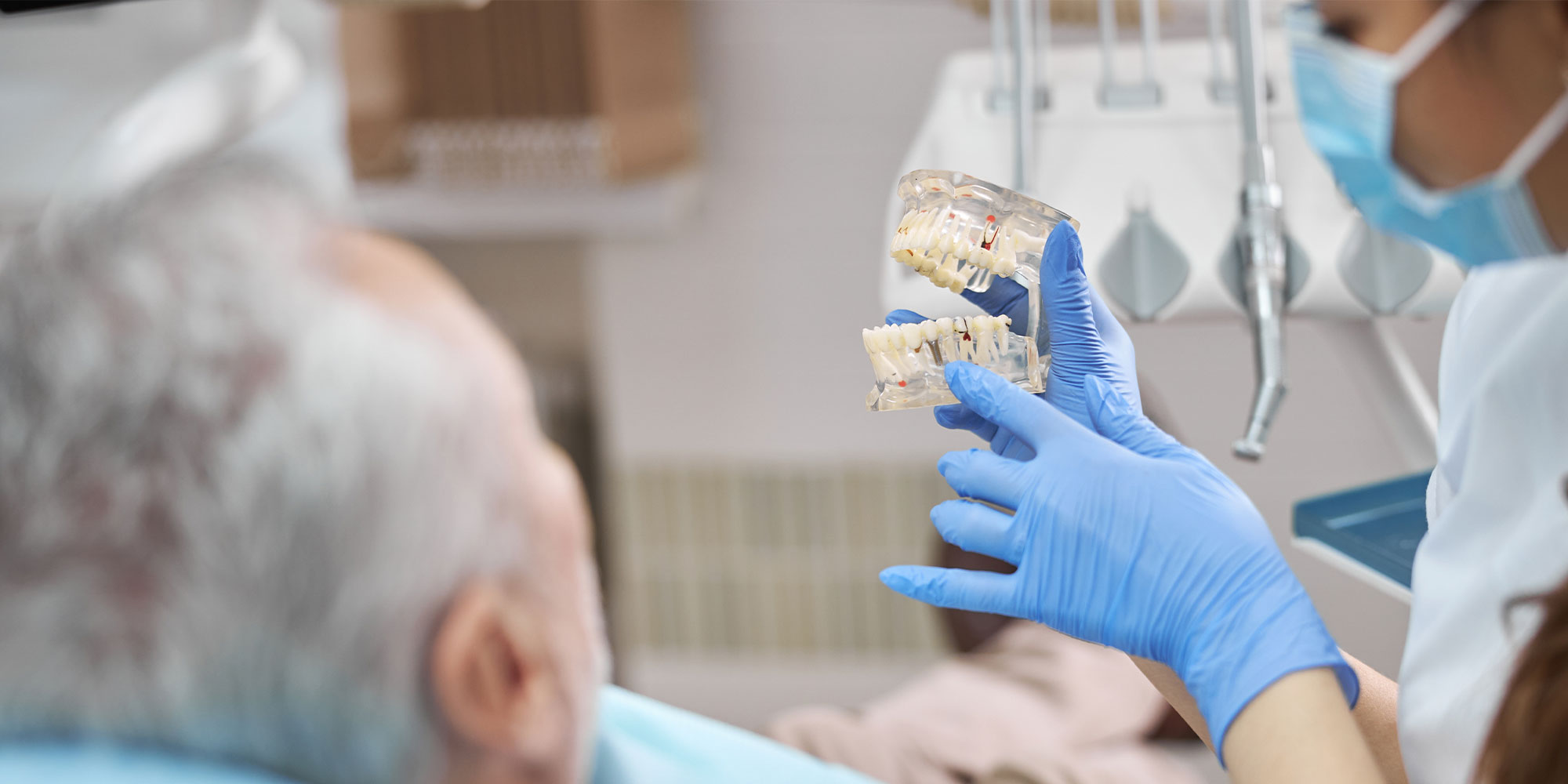 dental implant consultation, doctor holding full arch implants model