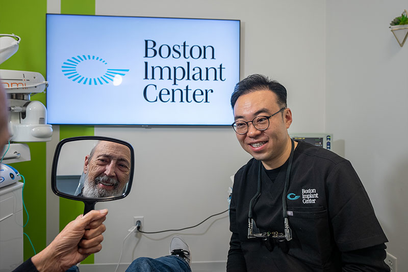 doctor smiling with patient after showing them there new smile